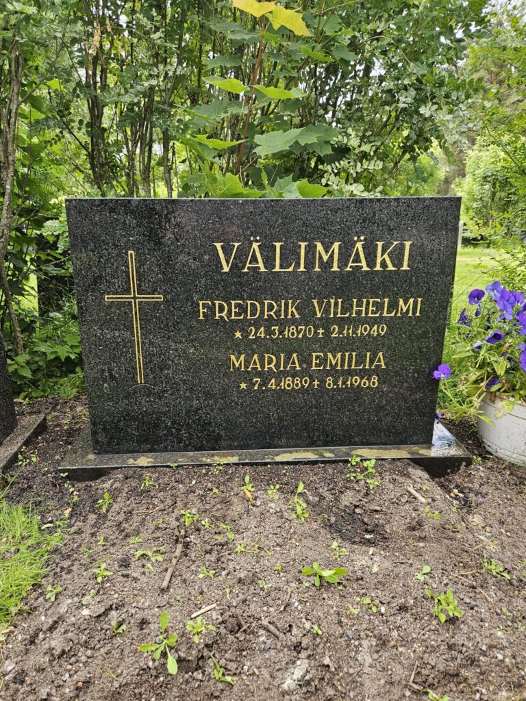 Tumma hautakivi kunnostuksen jälkeen, kun kaiverrusten kultaukset ovat jälleen selkeät
